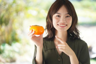 Image of a woman with a persimmon