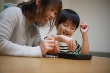 Parents and children playing with Othello 