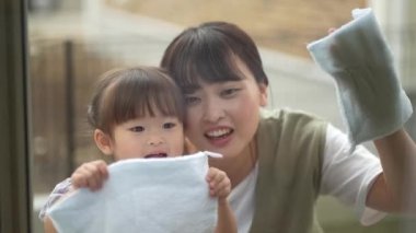 Parents and children cleaning windows 