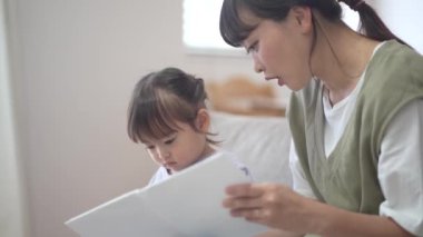 Ebeveynler ve çocuklar resim kitapları okuyor.