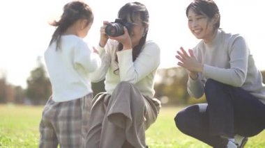 Anne çocukların fotoğraflarını çekiyor. 