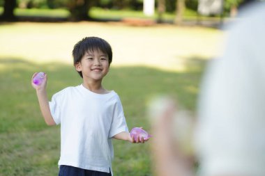 Parents and children playing with water balloons 
