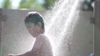 Boy frolicking in the shower 
