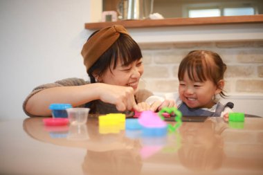 Ebeveynler ve çocuklar kille oynuyor 