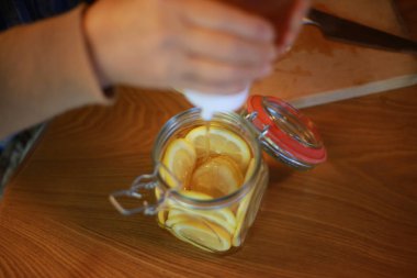 A woman making honey pickles of lemon 