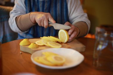 A woman making honey pickles of lemon 