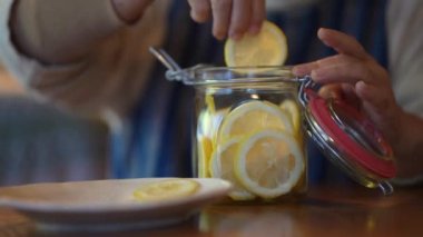 A woman making honey pickles of lemon 