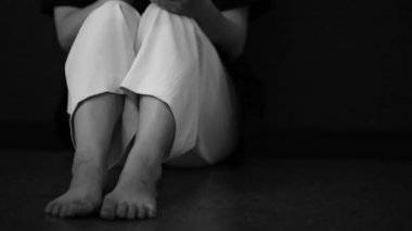 A woman who puts her smartphone on the floor and is depressed 