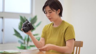 A woman who cares for the camera while looking at her smartphone
