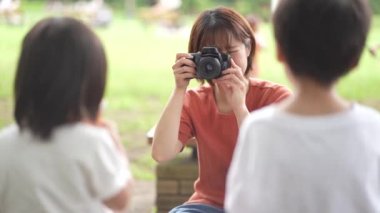 Anne çocukların fotoğraflarını çekiyor. 