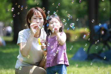 Ebeveynler ve çocuklar sabun köpüğüyle oynuyorlar