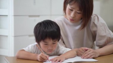 Boys and mothers studying in the living room