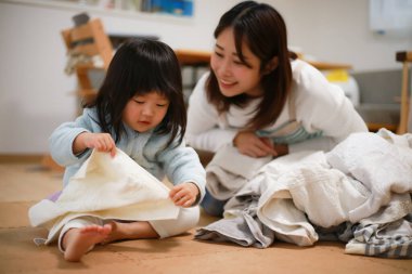 A girl helping to fold the laundry