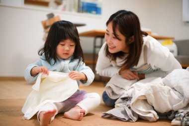 A girl helping to fold the laundry