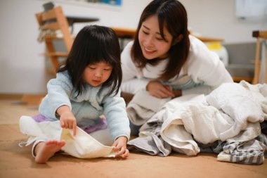 A girl helping to fold the laundry