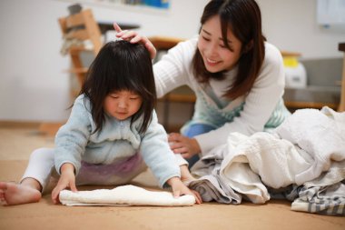 A girl helping to fold the laundry