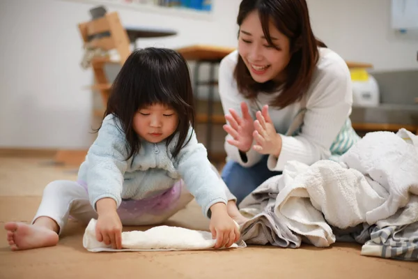 Girl Helping Fold Laundry — Stockfoto