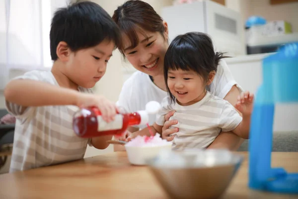 かき氷に親子でシロップをかける — ストック写真