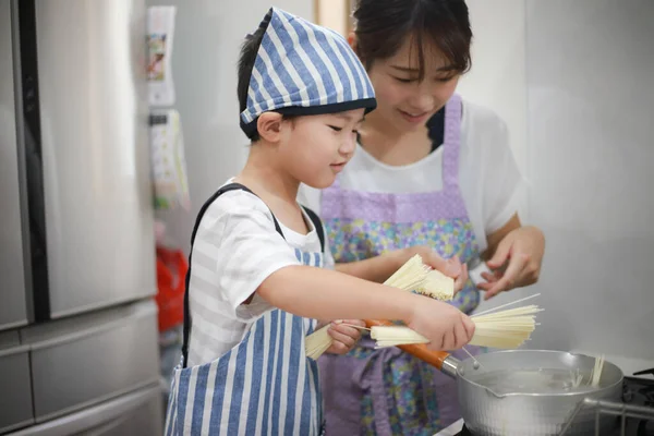 親子で素麺を茹でる — ストック写真