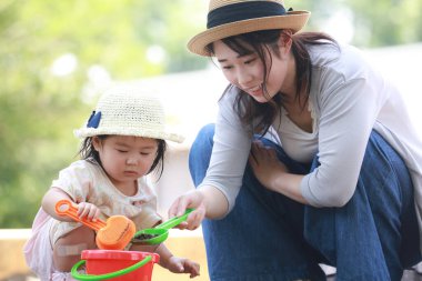 Image of parents and children playing in the sandbox 