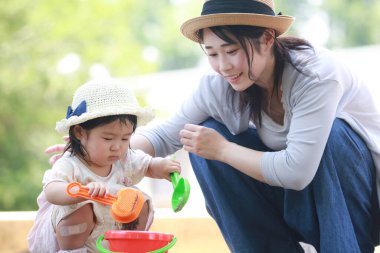 Image of parents and children playing in the sandbox 