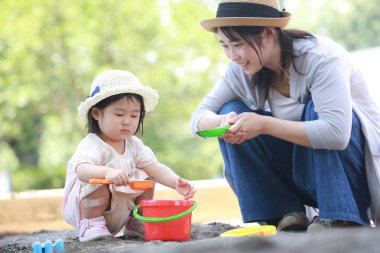 Image of parents and children playing in the sandbox 