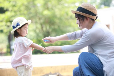 Parents and children spraying insect repellent