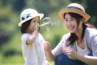 Image of parents and children playing with soap bubbles