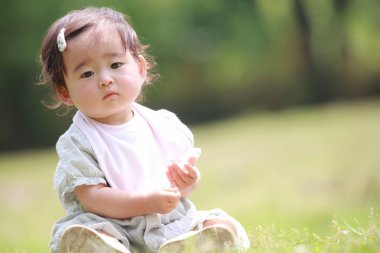 çimenlerin üzerine oturmuş bebek 