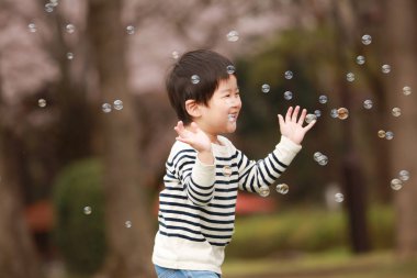 Image of a boy chasing a shabon ball 