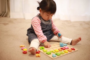 Image of a girl playing with an alphabet educational toy 