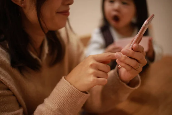 Genç Asyalı Anne Arka Planda Kızı Ile Birlikte Akıllı Telefon — Stok fotoğraf