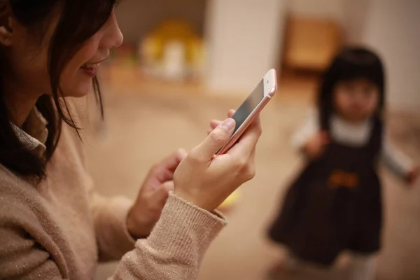 Giovane Madre Asiatica Utilizzando Smartphone Casa Con Sua Figlia Sullo — Foto Stock