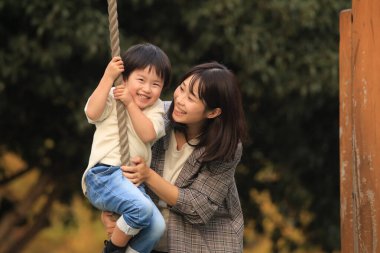 Asyalı anne ve oğlu parkta.