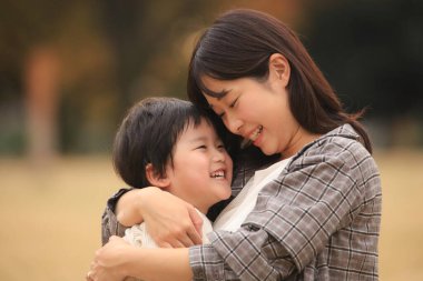 Parkta çocuklu mutlu bir Asyalı anne.