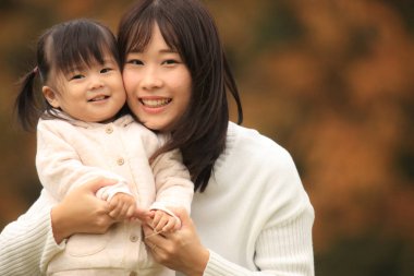 Portrait of happy young mother with her little daughter in the park