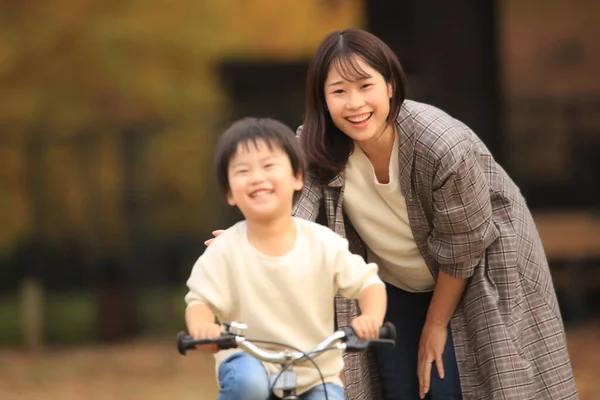 Fiatal Ázsiai Anya Tanítja Fiát Biciklizni Parkban — Stock Fotó