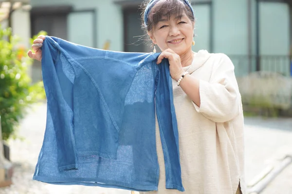 Japanese Senior Woman Holding Indigo Dyed Silk — стоковое фото
