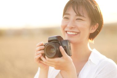 Parkta fotoğraf çeken güzel bir kadın.