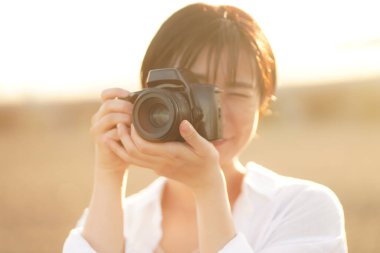 Parkta fotoğraf çeken güzel bir kadın.