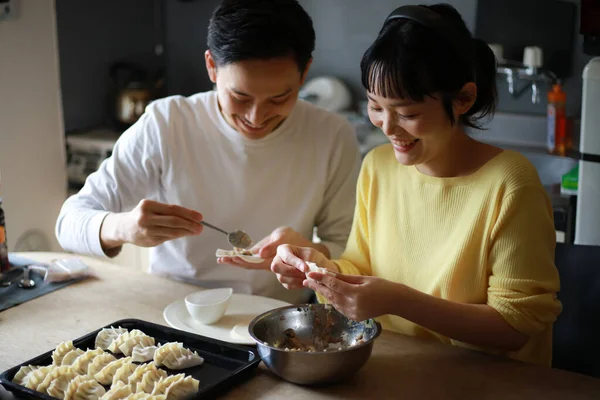 一对年轻夫妇在家里厨房里做饭 — 图库照片