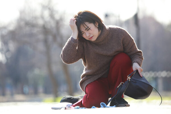 расстроенная молодая женщина держала сумку на улице