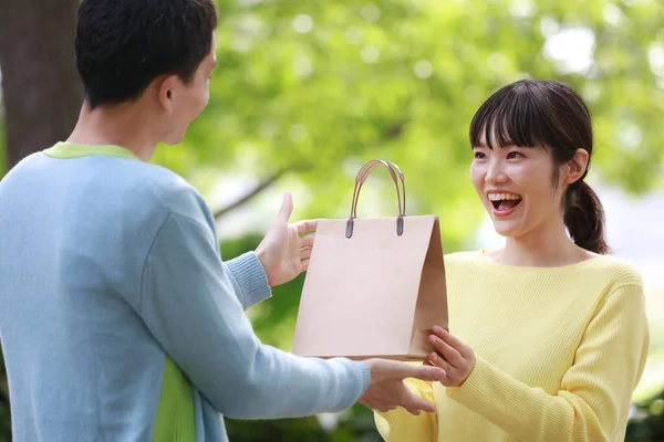 Man Geeft Een Geschenk Papieren Zak Aan Zijn Vrouw — Stockfoto