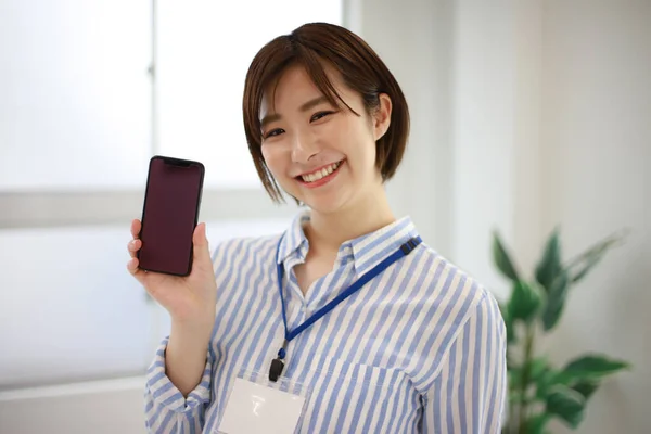 亚洲的年轻女性 办公室里有智能手机 — 图库照片
