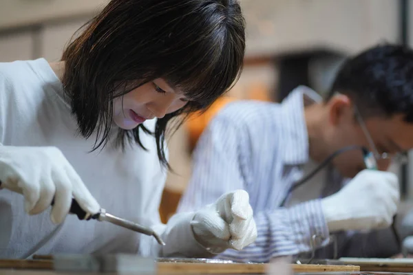 年轻的亚洲女人用烙铁做漂亮的装饰 — 图库照片