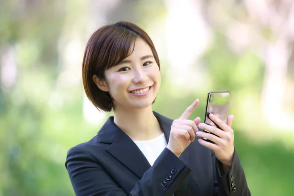 一个年轻美丽的亚洲女商人的肖像 带着手机 — 图库照片
