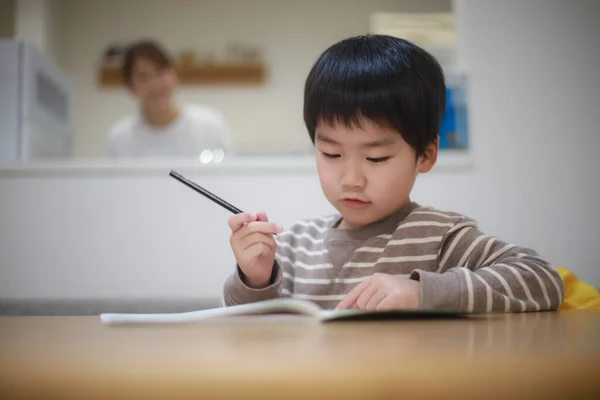 亚洲小男孩在笔记本上写字 — 图库照片