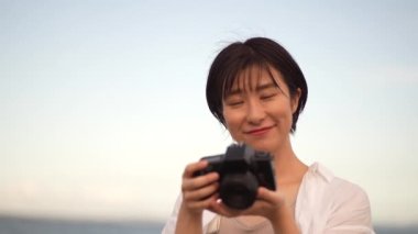 Denizde fotoğraf çeken kadın.