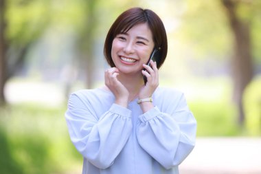 Telefonu olan Asyalı bir kadının portresi.