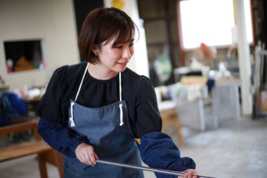 Cam bir kap yapan bir kadın.